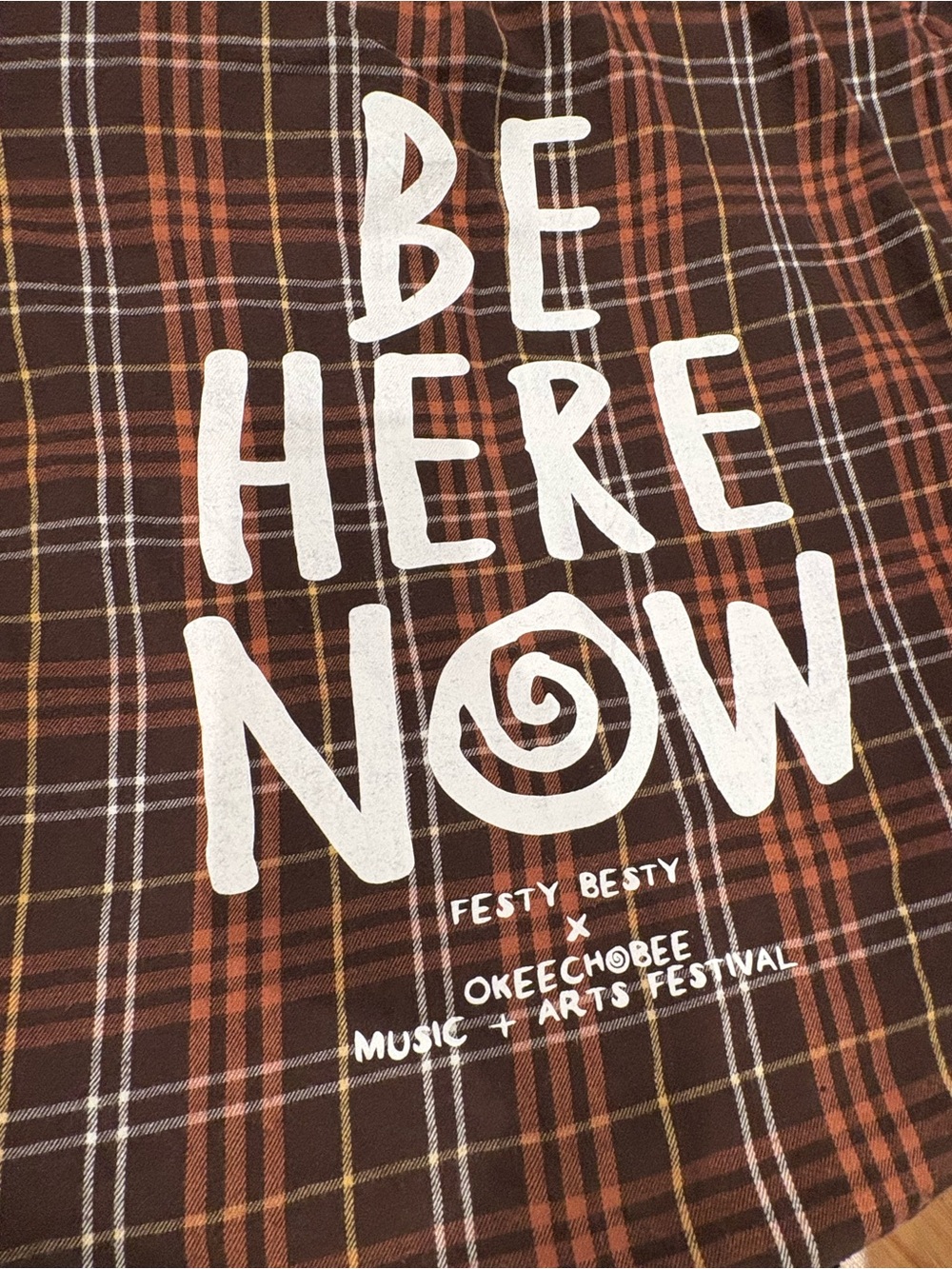 Okeechobee Be Here Now Graphic Plaid Tee - White Print on Brown/Orange Plaid